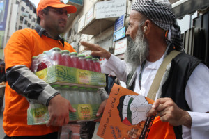 Palestinian demonstrators carry posters demanding Palestinian merchants to boycott Israeli settlement products in 2011. (Photo by Issam Rimawi/FLASH90)