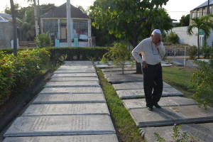 Jewish community leader Ainsley Henriques walks on historic gravestones engraved with Hebrew inscriptions. (AP/David McFadden)