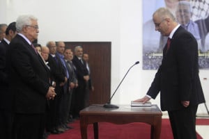Palestinian President Mahmoud Abbas (L) and the new unity government Prime Minister Rami Hamdallah (R) during the swearing in ceremony of the government at the Palestinian Authority's headquarters in Ramallah. (Issam RImawi/FLASH90)