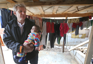 Jan Egeland, the secretary general of the Norwegian Refugee Council and former U.N. humanitarian chief, holds a Syrian baby during his visit to a refugee camp in the town of Marej  in the Bekaa valley, Lebanon. (AP/Hussein Malla)