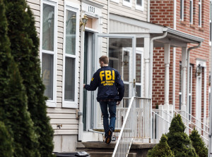 An FBI Joint Terrorism Task Force member enters a home in Harrisburg, Pa., last Tuesday, where Jalil Ibn Ameer Aziz, 19, was arrested. (James Robinson/PennLive.com via AP) MANDATORY CREDIT; MAGS OUT