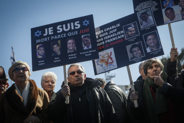 Mourners in Paris hold signs saying, "I am dead, because I'm a Jew." (Miriam Alster/Flash90)