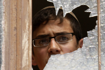Jewish man peers through broken window. (Photo: Nati Shohat/Flash90)