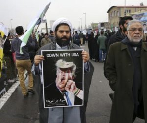 A cleric holds a caricature of US President Donald Trump in an annual rally commemorating the 1979 Islamic revolution. (AP)