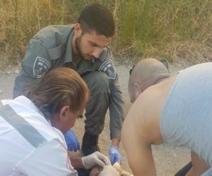 Border Police paramedic treating Arab child in Hebron
