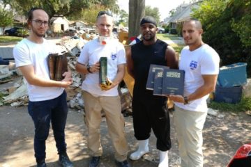 ZAKA volunteers with Houston resident Adrian and Jewish books recovered intact from his home