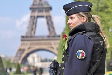 A French police officer patrols with the Eiffel Tower in background