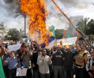 Palestinians burn an Israeli flag. (Abed Rahim Khatib/Flash 90)