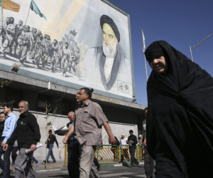 Iranians in front of an Ayatollah Khomeini poster. (AP Photo/Vahid Salemi)