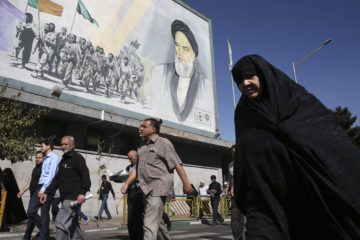 Iranians in front of an Ayatollah Khomeini poster. (AP Photo/Vahid Salemi)