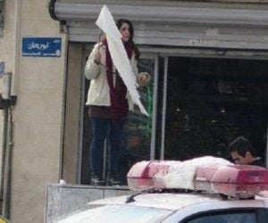 A woman in Iran breaks the law b removing her headscarf. (Twitter)