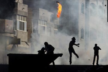 A Palestinian terrorist throws a fire bomb