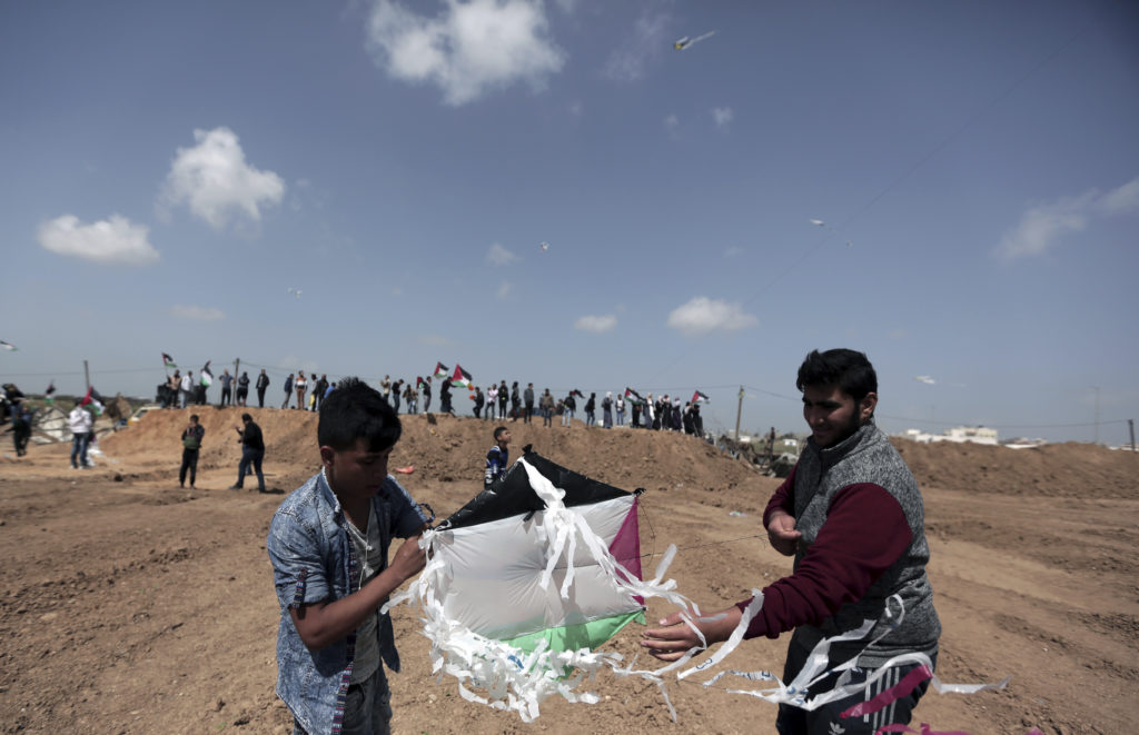 Palestinians fly kites near the Gaza border with Israel. (AP Photo/Khalil Hamra)