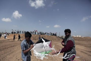 Palestinians fly kites near the Gaza border with Israel. (AP Photo/Khalil Hamra)