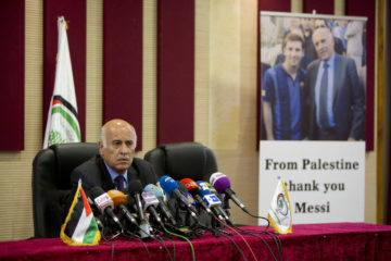 Palestinian Football Association Jibril Rajoub with photo of superstar Lionel Messi. (AP Photo/Majdi Mohammed)