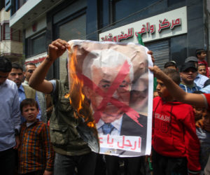 Palestinians burn a poster of Mahmoud Abbas. (Abed Rahim Khatib/Flash90)