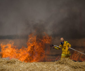 Israeli firefighters extinguish a fire near the Gaza border. (Yonatan Sindel/Flash90)