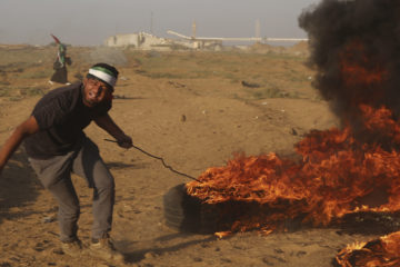 A rioter in Gaza sets a fire. (AP Photo/Adel Hana)