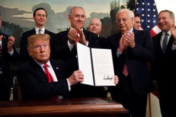 President Donald Trump and a signed proclamation recognizing Israel's sovereignty over the Golan Heights. (AP Photo/Susan Walsh)