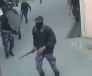 Hamas member beating protesters. (screenshot)
