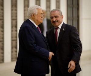 Mohammad Ishtayeh, right, shakes hands with Mahmoud Abbas. (AP Photo/Majdi Mohammed)