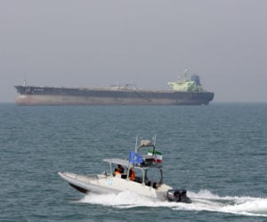 Iranian Revolutionary Guard speedboat and an oil tanker. (AP Photo/Vahid Salemi, File)