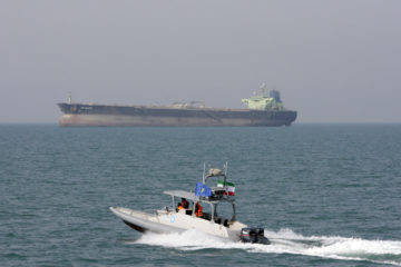 Iranian Revolutionary Guard speedboat and an oil tanker. (AP Photo/Vahid Salemi, File)