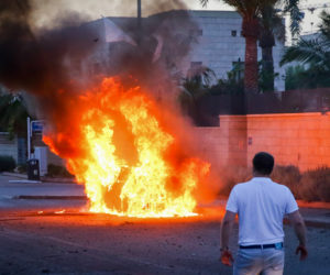 A car bursts into flames after it was hit by a rocket fired from the Gaza Strip in the southern Israeli city of Ashdod. (Flash90)