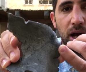 Israeli Yedidya HArush shows shrapnel from a Palestinian rocket that hit his property. (screenshot)
