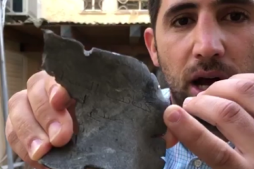 Israeli Yedidya HArush shows shrapnel from a Palestinian rocket that hit his property. (screenshot)