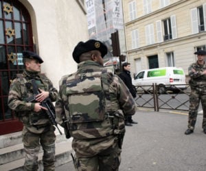 Soldiers stand guard outside a synagogue in Paris, France. (AP Photo/Christophe Ena)