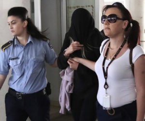 Cypriot police escort the 19-year-old British woman, center, Monday, July 29, 2019. after she was arrested on suspicion of filing a false complaint of gang rape against a group of Israeli teens.