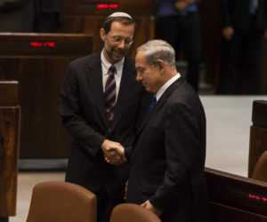 Israel's Prime Minister Benjamin Netanyahu, right, shakes hands with then-Likud MK Moshe Feiglin in the Knesset, on July 2, 2013.
