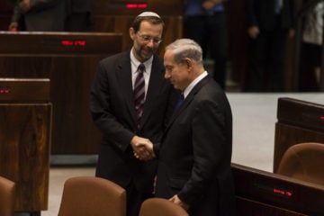 Israel's Prime Minister Benjamin Netanyahu, right, shakes hands with then-Likud MK Moshe Feiglin in the Knesset, on July 2, 2013.