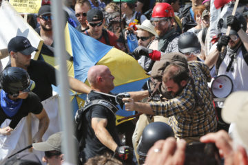 White nationalist demonstrators clash with counter demonstrators at the entrance to Lee Park in Charlottesville, Va., on Aug. 12, 2017.