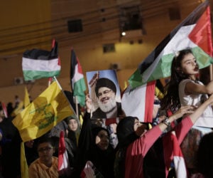 Supporters of Hezbollah leader Hassan Nasrallah wave Palestinian flags during a rally in a southern suburb of Beirut, Lebanon, Friday, May 31, 2019.