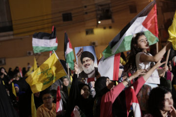 Supporters of Hezbollah leader Hassan Nasrallah wave Palestinian flags during a rally in a southern suburb of Beirut, Lebanon, Friday, May 31, 2019.
