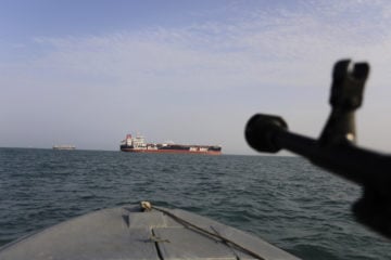 In this July 21, 2019 file photo, a speedboat of Iran's Revolutionary Guard trains a weapon toward the British-flagged oil tanker Stena Impero, which was seized in the Strait of Hormuz.