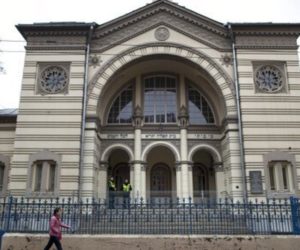 In this photo taken on Wednesday, Oct. 31, 2018, a woman walks past a synagogue in Vilnius, Lithuania.