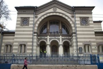 In this photo taken on Wednesday, Oct. 31, 2018, a woman walks past a synagogue in Vilnius, Lithuania.