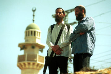 settlers stand near a mosque in Hebron