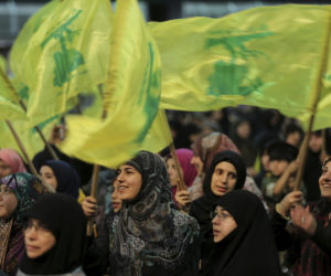 Hezbollah supporters wave their group's flag