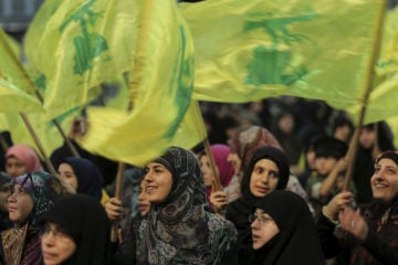 Hezbollah supporters wave their group's flag