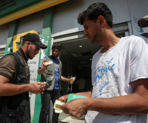 Palestinians receive Qatari cash aid of $100 from the post office in Rafah in the southern Gaza Strip, on August 27, 2019.
