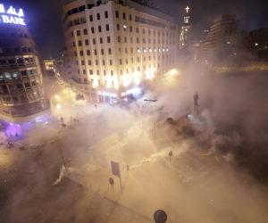 Lebanese riot police fire tear gas during a protest against government's plans to impose new taxes, in Beirut, Lebanon, Friday, Oct. 18, 2019.