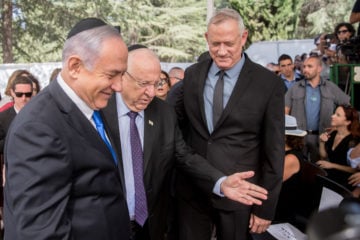 President Reuven Rivlin, center, showing the way to Prime Minister Benjamin Netanyahu, left, and Blue and White leader Benny Gantz, at a memorial ceremony for the late President Shimon Peres in Jerusalem, on September 19, 2019.