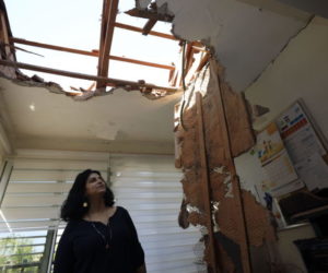 A woman looks at the damage to a house in Sderot