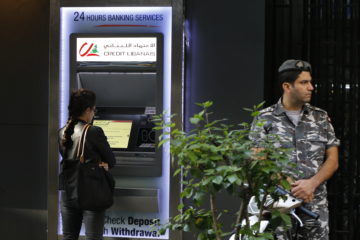 A woman uses ATM outside a bank