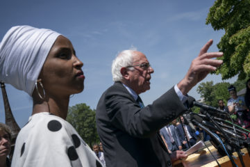 Democratic presidential candidate, Sen. Bernie Sanders, I-Vt., center, joined at left by Rep. Ilhan Omar, D-Minn.