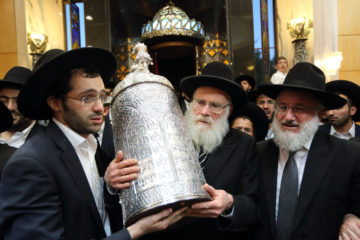 Religious Jews dance with a Torah scroll
